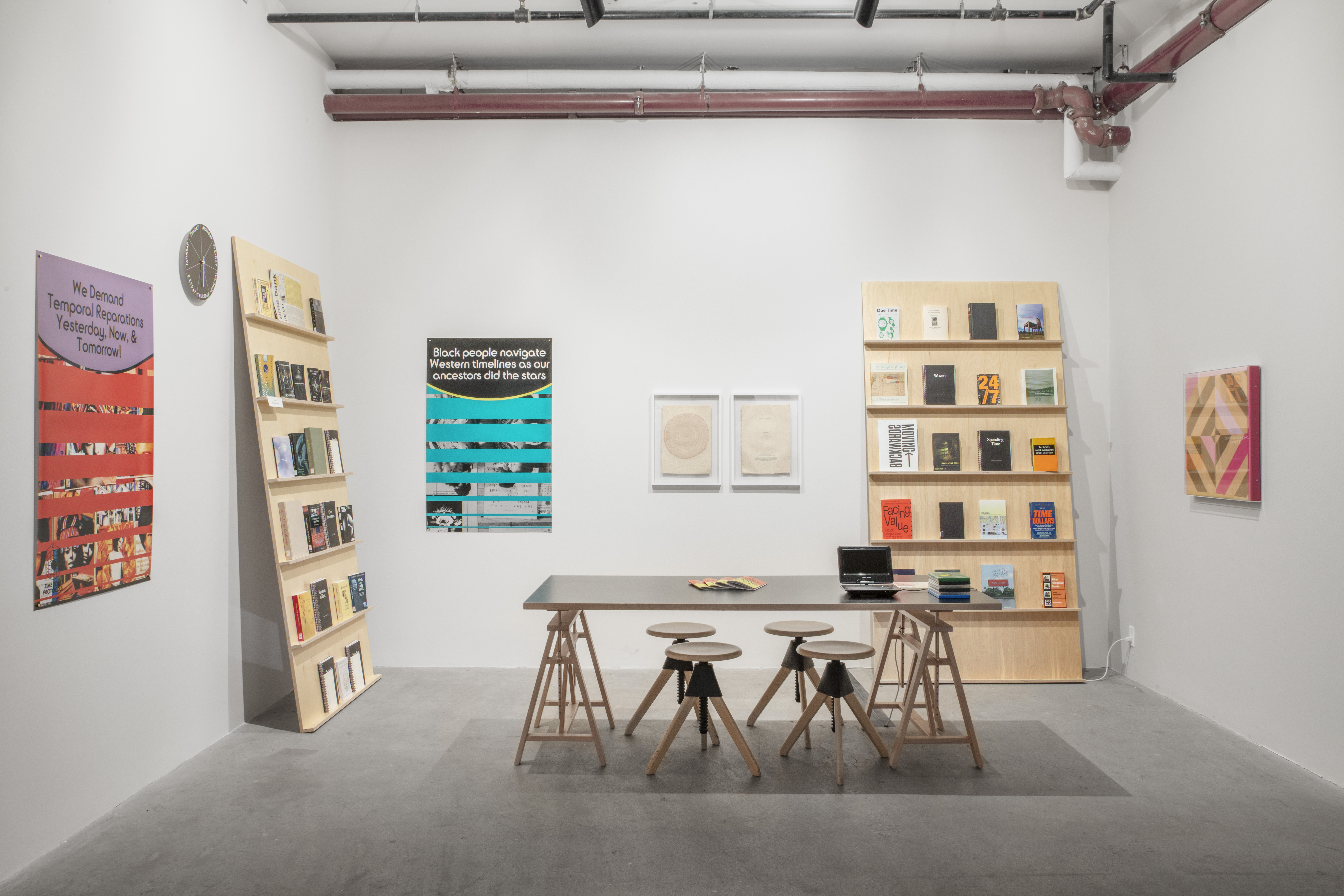 Photograph of a reading room, with graphic posters and shelves displaying reading materials along the walls. In the center is a long table with seats around it.